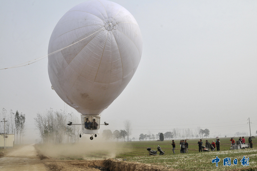 2015年10月23日，河南商丘，29岁男子时松波自费30万元历时4个月研制的一艘10米长23米高的两座载人飞艇，经过八次试飞，终于在田间道路上成功起飞。 中国日报亚洲新闻图片网 吕忠箱 摄影