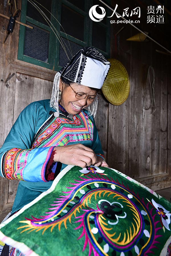 1月29日，平江乡滚仲村一苗族妇女在绣制作“百鸟衣”的绣片。王炳真 摄