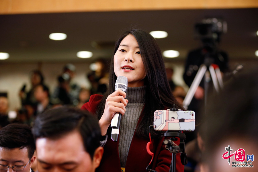 2016年3月3日，全国政协十二届四次会议开幕会，身穿暗红色小西装的新京报记者向会议发言人提问。中国网 杨佳 摄