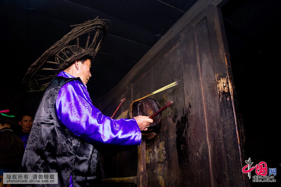  在鼓头家里，把同样的祭品摆在木鼓前，鼓头身穿缎长衫，头戴已抽掉粽粑叶只剩竹篾骨架的斗笠，率参加祭鼓的人站立，鼓头念祭祷词，烧香纸酹酒掐食祭木鼓，鼓头口含酒水喷洒木鼓三次，然后用鼓棒敲鼓数下，仪式结束。中国网图片库 张晖 摄