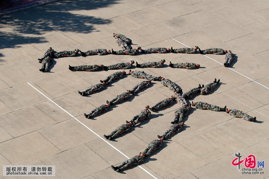 2011年10月1日，黑龙江黑河，战士们用“睡姿”摆出大大的“家”字，以此来表达他们内心深处对祖国的忠诚和对亲人的思念之情。中国网图片库 魏建顺 摄