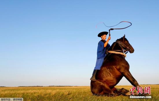 资料图:古老的牧民在草原上牧马。