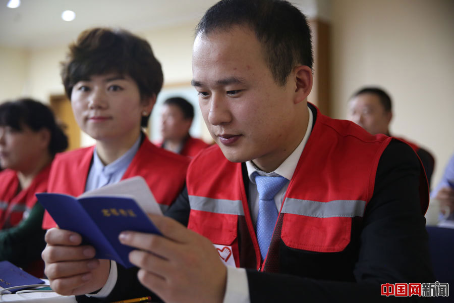 志愿者翻看志愿者证。西城区红十字会许伯宁摄