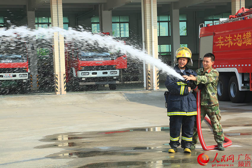 消防战士在教陈晓均学习使用水枪。（新消 供图）