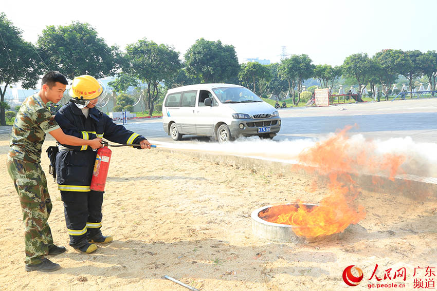 陈晓均（右）学习灭火。（新消 供图）