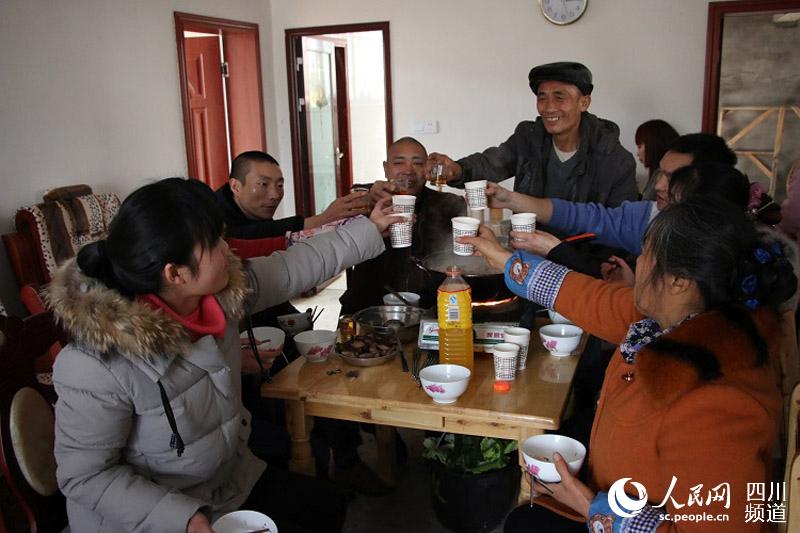 代芝良一家吃火锅，举杯迎新年。（张枥 摄）