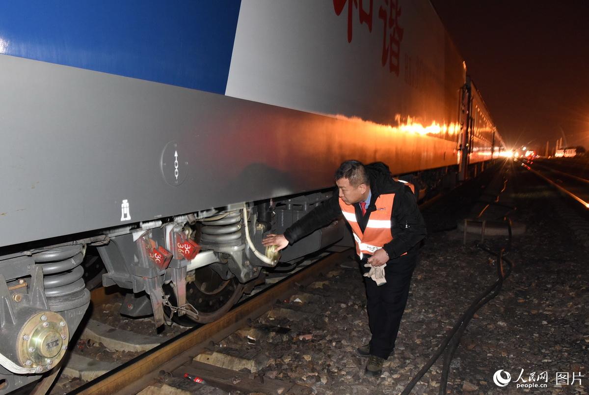 2017年2月3日，司机孙日峰对火车头开车前检查机车。