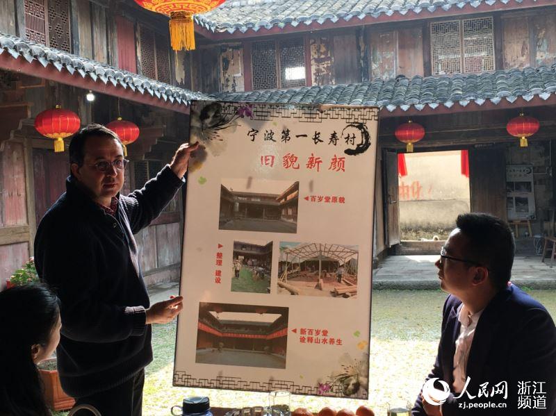 丁一牧向客人介紹河洪村村莊改造前后對比。陳金蓮 攝
