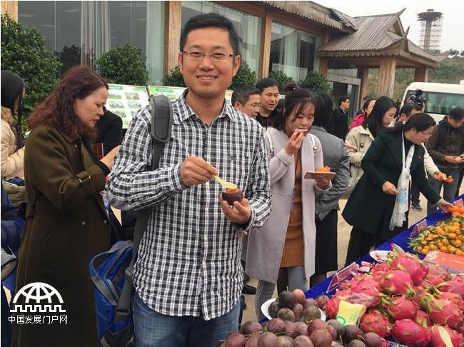 图为村民邀请媒体记者品尝村民自己种的水果 王东海摄影