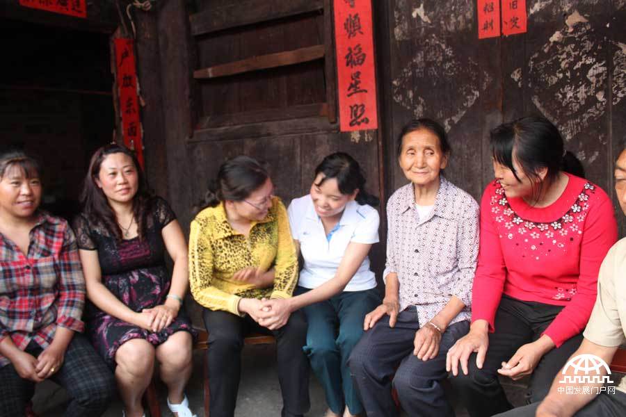盘县乐民镇海子村当地妇联干部与“两癌”项目受益贫困妇女亲切交谈。