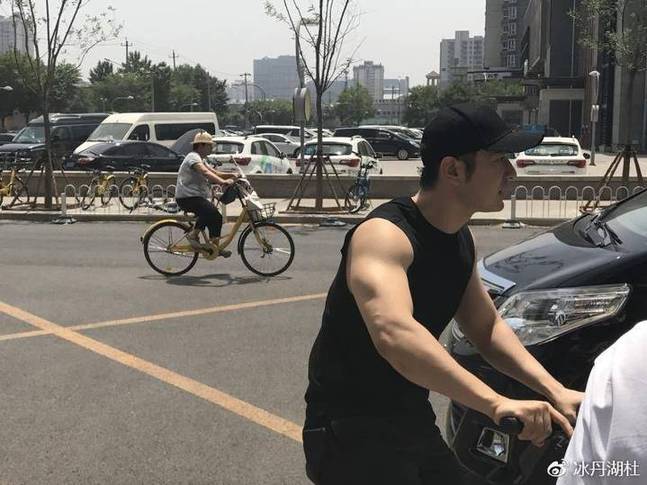黄晓明骑自行车现身街头 休闲造型随性十足