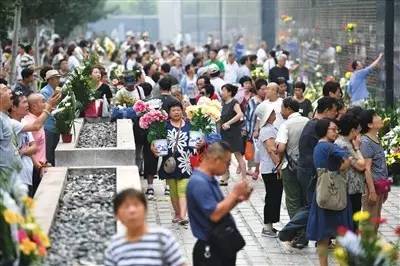 ▲7月28日，市民在地震纪念墙前祭奠遇难的亲人。新华社记者 牟宇 摄