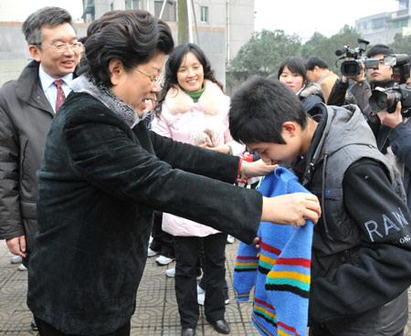 Chen Zhili (L), president of All-China Women's Federation and vice chairwoman of the Standing Committee of China's National People's Congress, selects a sweater for a student who lost parents during the devastating earthquake hitting Sichuan on May 12, 2008 at Tanghu High School in Dujiangyan City, southwest China's Sichuan Province, on January 6, 2009.
