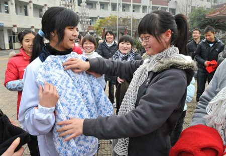 Two girl students who lost parents during the devastating earthquake hitting Sichuan on May 12, 2008 select donated sweaters at Tanghu High School in Dujiangyan City, southwest China's Sichuan Province, on January 6, 2009.