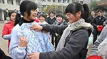 Two girl students who lost parents during the devastating earthquake hitting Sichuan on May 12, 2008 select donated sweaters at Tanghu High School in Dujiangyan City, southwest China's Sichuan Province, on January 6, 2009.