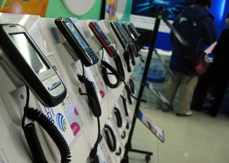 Customers try third-generation (3G) mobile phones at a China Mobile exhibition hall in Beijing, China, on January 7, 2009. China's telecommunications supervisor, the Ministry of Industry and Information Technology, on Wednesday issued the long-awaited third-generation (3G) mobile phone licenses to three mobile operators, namely China Mobile, China Telecom and China Unicom.