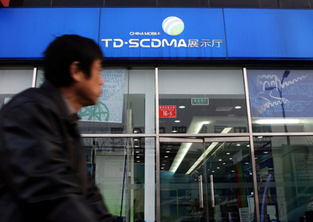 A man rides past a China Mobile exhibition hall in Beijing, China, on January 7, 2009.