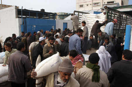 Palestinian refugees receive food in aid from an office of the United Nations in Gaza City on January 8, 2009. [Xinhua]