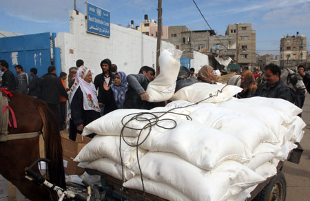 Palestinian refugees receive food in aid from an office of the United Nations in Gaza City on January 8, 2009. [Xinhua]