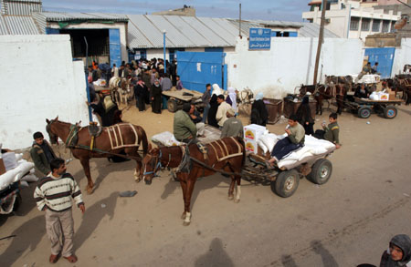 Palestinian refugees receive food in aid from an office of the United Nations in Gaza City on January 8, 2009. [Xinhua]