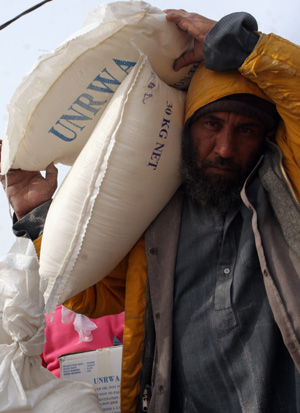 Palestinian refugees receive food in aid from an office of the United Nations in Gaza City on January 8, 2009. [Xinhua] 