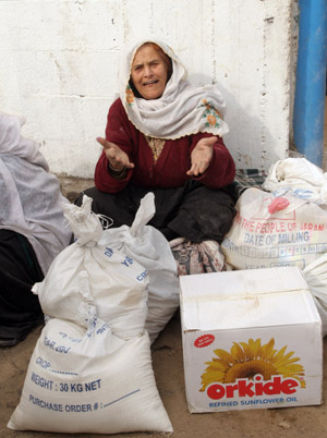 A Palestinian female refugee receives food in aid from an office of the United Nations in Gaza City on January 8, 2009. [Xinhua]