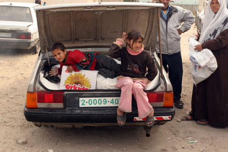 Palestinian refugees receive food in aid from an office of the United Nations in Gaza City on January 8, 2009. [Xinhua]