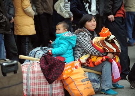 A woman rests with her children outside the Hangzhou Railway Station in Hangzhou, capital of east China's Zhejiang Province, on January 8, 2009. The Spring Festival travel period, known as Chunyun in Chinese, began to see its passenger peak as the college students and migrant workers started to return home.