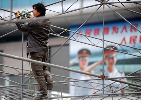 A worker builds the framework of tents to shelter ticket buyers from winter cold at the open ground of the Guiyang Railway Station in Guiyang, capital of southwest China's Guizhou Province, on January 7, 2009, prior to the Chinese lunar New Year starting from January 26. Hundreds of millions of Chinese people are expected to move around by means of railway during the lunar New Year holidays.