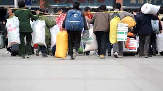 Migrant workers enter the Changsha Railway Station in Changcha, capital of central-south China's Hunan Province, on January 8, 2009. The Spring Festival travel period, known as Chunyun in Chinese, began to see its passenger peak in Changsha as the college students and migrant workers started to return home.