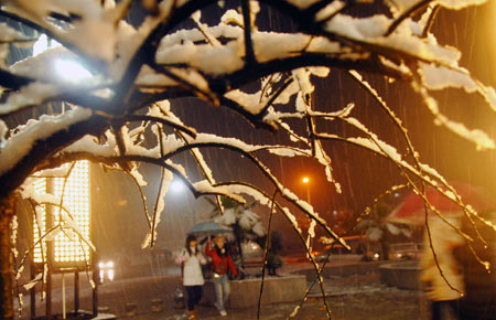 Students walk at the snow-capped campus of China Three Gorges University in Yichang, central China's Hubei Province, on January 5, 2009. The Meteorological Observatory of Yichang issued blue alert of heavy snow Monday. 