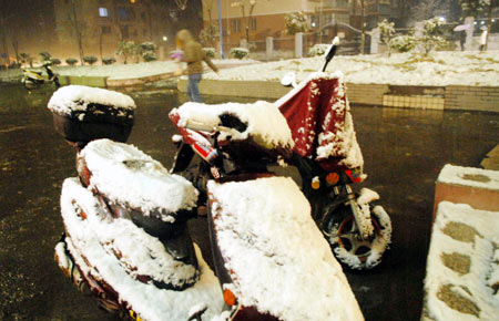 Students walk at the snow-capped campus of China Three Gorges University in Yichang, central China's Hubei Province, on January 5, 2009. The Meteorological Observatory of Yichang issued blue alert of heavy snow Monday.