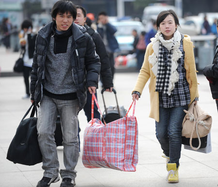 People carry baggages as they walk on the square of the Changsha Railway Station in Changsha, capital of central-south China's Hunan Province, on January 8, 2009. The Spring Festival travel period, known as Chunyun in Chinese, began to see its passenger peak in Changsha as the college students and migrant workers started to return home.