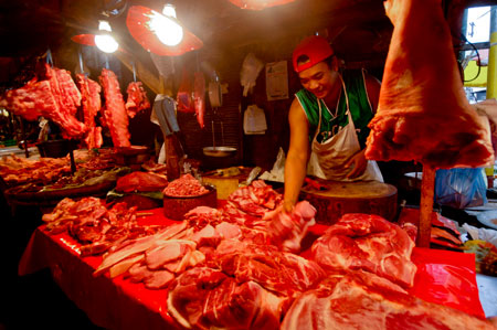 A meat vendor sells pork at a market in Manila, capital of the Philippines, on January 8, 2009. A team of international experts is investigating the Ebola Reston virus found in pigs at two farms in the northern Philippines, the World Health Organization (WHO) said on Thursday. 