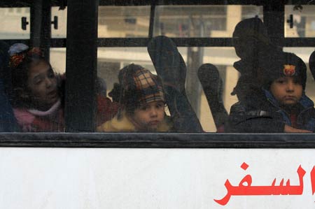 Palestinian children with dual citizenship look out of a bus as they leave the Gaza Strip with family on January 8, 2009.