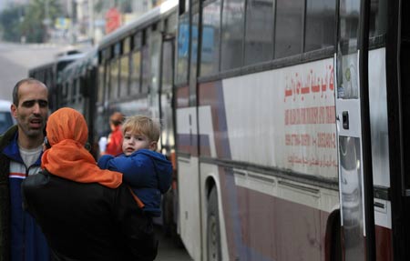 A Palestinian mother and her son with dual citizenship wait outside a bus before they leave the Gaza Strip on January 8, 2009. 