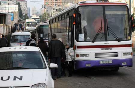 A Palestinian family with dual citizenship stands outside a bus before they leave the Gaza Strip January 8, 2009.