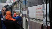 A Palestinian mother and her son with dual citizenship wait outside a bus before they leave the Gaza Strip on January 8, 2009.