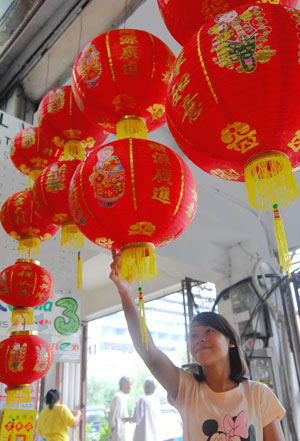 A girl picks red lanterns at the Chinatown in Jakarta, captial of Indonesia, on Jan. 8, 2009. As the traditional Chinese Spring Festival is coming, red lanterns, mascots and various decorations come in to market in Jakarta.