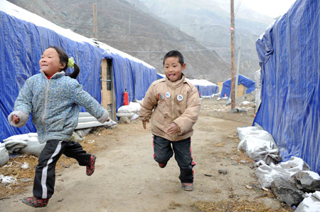 He Tingjie (R) of Lianhe Village of Wenchuan County plays with another kid at a settlement in southwest China's Sichuan Province, on January 8, 2009. 