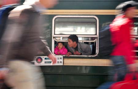 A man looks out from a window of train's carriage in Guangzhou Railway Station, in China's south Guangdong Province, on January 11, 2009. The 40-day travel peak before, during and after the Spring Festival holiday began on Sunday, with the estimation of 2.32 billion people to travel over the Chinese Lunar New Year holiday. 