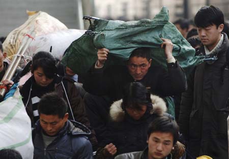 Migrant workers backing luggages arrive at Fuyang Railway Station, in China's central Anhui Province, on January 11, 2009. The 40-day travel peak before, during and after the Spring Festival holiday began on Sunday, with the estimation of 2.32 billion people to travel over the Chinese Lunar New Year holiday.