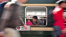 A man looks out from a window of train's carriage in Guangzhou Railway Station, in China's south Guangdong Province, on January 11, 2009. The 40-day travel peak before, during and after the Spring Festival holiday began on Sunday, with the estimation of 2.32 billion people to travel over the Chinese Lunar New Year holiday.