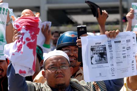 People hold a demonstration in front of the United States Embassy to Malaysia to protest against the US support for Israel's continued military attacks on the Palestinians in the Gaza Strip, in Kuala Lumpur, Jan. 9, 2009. 