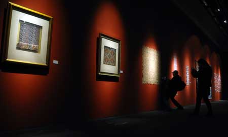 Visitors take photos of exhibits at an arts and crafts exhibition at the Art Gallery of China in Beijing, capital of China, Jan. 9, 2009. 