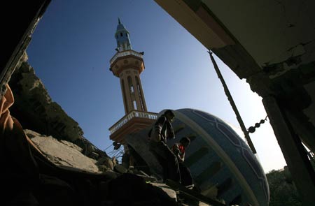 Two Palestinians inspect the ruins of the al-Fadilah mosque which was destroyed in an Israeli air strike in Rafah in the southern Gaza Strip on January 11, 2009. Israeli troops continued their air and ground offensive to the Gaza strip on Sunday. According to Gaza emergency department, the death toll since the beginning of the offensive has mounted to 900. [Xinhua]