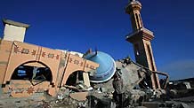 A Palestinian walks past the ruins of the al-Fadilah mosque, which was destroyed in an Israeli air strike in Rafah in the southern Gaza Strip on January 11, 2009. Israeli troops continued their air and ground offensive to the Gaza strip on Sunday. According to Gaza emergency department, the death toll since the beginning of the offensive has mounted to 900. [Xinhua]