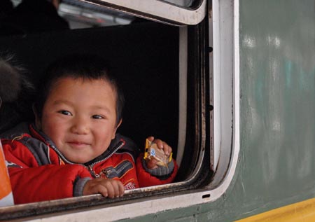 A child looks out of the train window at the Guiyang Railway Station in Guiyang, capital of southwest China's Guizhou Province, on January 11, 2009. The 40-day Spring Festival transportation, or Chunyun in Chinese, began on Sunday, with the estimation of 2.32 billion people to travel over the Chinese lunar New Year starting from January 26 this year. 
