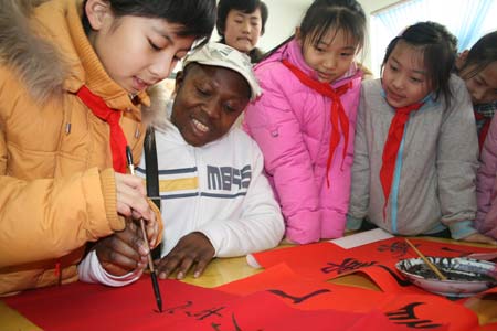 Foreign teacher Del learns to write the spring couplets under a student's guide at Boxing County, east China's Shandong Province, on January 11, 2009, to welcome the forthcoming Chinese traditional Spring Festival which falls on January 26 this year.