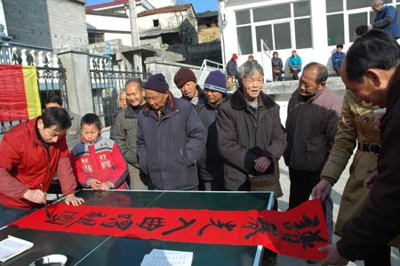 A folk calligrapher writes spring couplets for the local residents in Tangkou Township, east China's Anhui Province, on January 11, 2009, to welcome the forthcoming Chinese traditional Spring Festival which falls on January 26 this year.